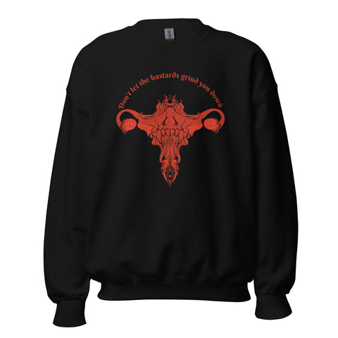 Black unisex sweatshirt featuring original uterus illustration and "Don't Let Them Grind You Down" text in red.