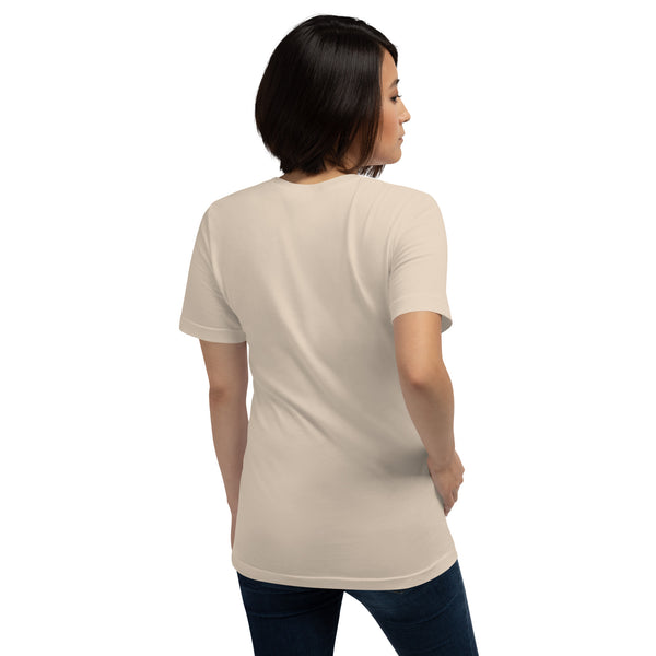 Back view of a woman wearing a beige unisex t-shirt, showcasing its soft fabric and comfortable fit.