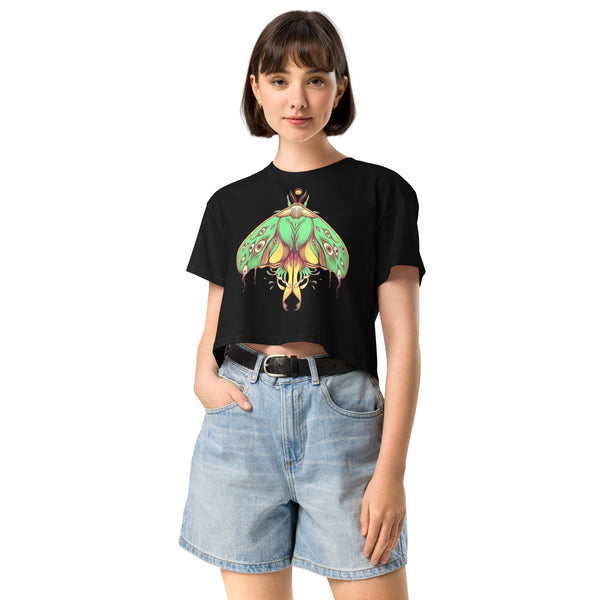 Woman wearing a black Luna Moth relaxed crop top with hand-drawn green luna moth artwork, matching a gothic or witchy aesthetic.